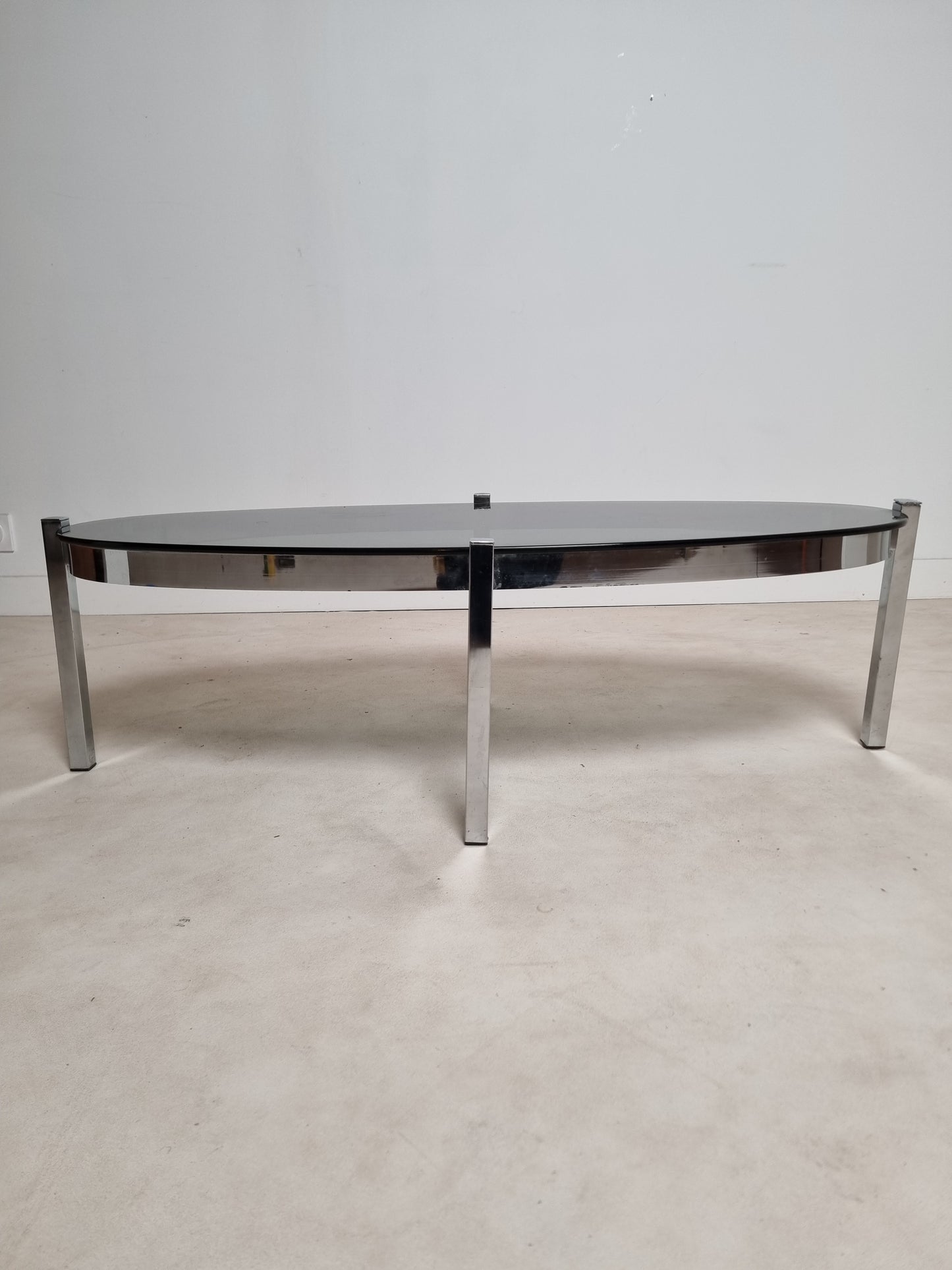 Table basse ovale en métal chromé et au verre fumé