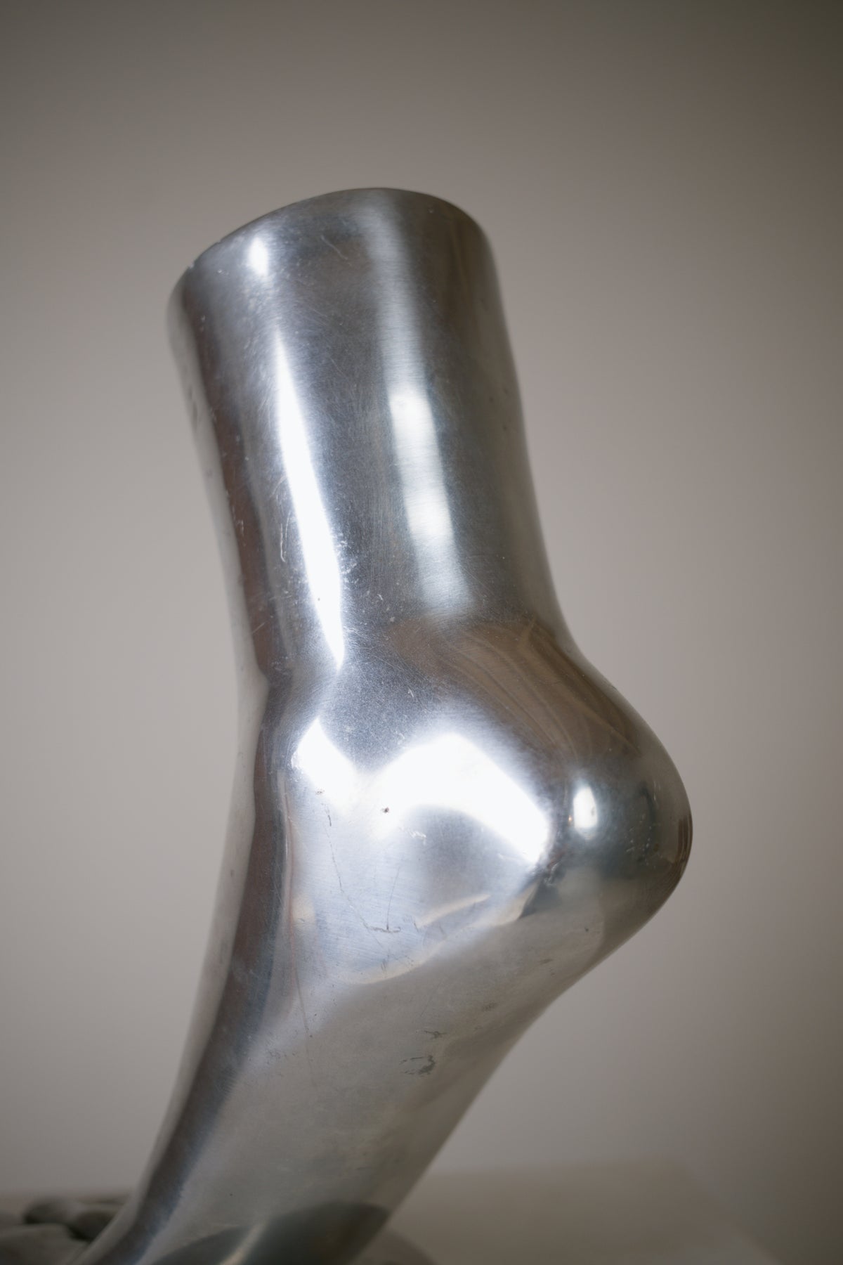 Pied sculptural en aluminium poli 