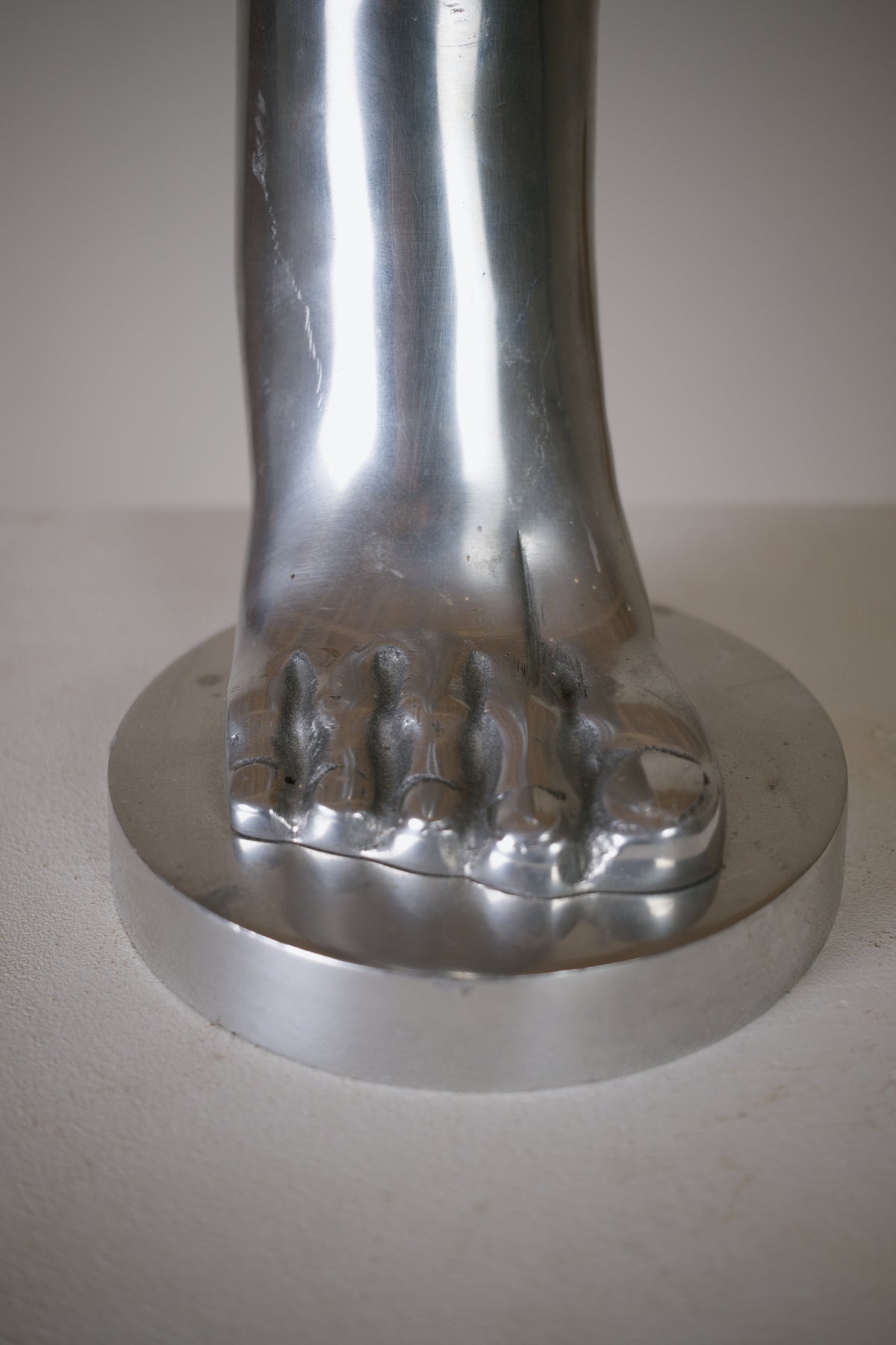 Pied sculptural en aluminium poli 
